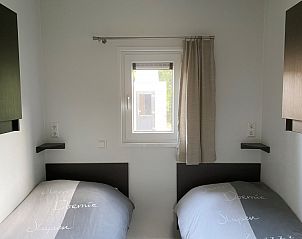 Sfeervolle slaapkamer met twee bedden in ZONICE chalet, Formerum, Terschelling.