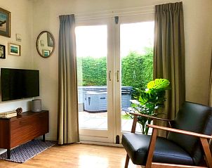 Gezellige binnenruimte met uitzicht op tuin bij Huisje Bloesem, chalet in Formerum, Terschelling, Waddeneilanden.