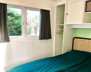 Slaapkamer met uitzicht op groen bij Huisje Bloesem, een chalet in Formerum, Terschelling, Waddeneilanden.