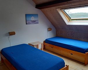 Slaapkamer met dakraam in Heestervin appartement, Hee, Terschelling voor natuurlijke lichtinval.