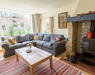 Gezellige woonkamer in De Sjouw, Hoorn, Terschelling, met comfortabele zithoek en houtkachel.