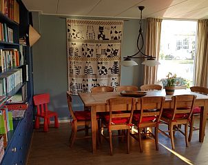 Lichte eetruimte in De Sjouw, vakantiehuis in Hoorn, Terschelling, met uitzicht op de tuin.