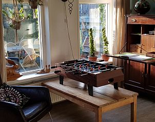 Speelhoek in De Sjouw, Hoorn, Terschelling, met tafelvoetbal en uitzicht op de tuin.