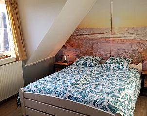 Slaapkamer in De Sjouw, Hoorn, Terschelling, met tweepersoonsbed en rustgevend strandthema.
