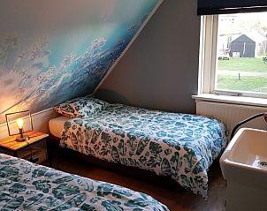 Tweepersoonskamer in De Sjouw, vakantiehuis in Hoorn, Terschelling, met uitzicht op de groene omgeving.