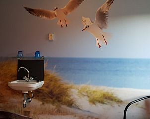 Kamer in De Sjouw, Hoorn, Terschelling, met maritiem thema en wastafel.