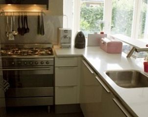 Moderne keuken in vakantiehuis Oosterkooi in Hoorn, Terschelling met tuinzicht.