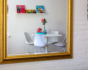 Stijlvolle eetruimte weerspiegeld in spiegel van Casa Juan Carlos vakantiehuis op Terschelling.