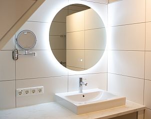 Moderne badkamer met verlichte spiegel in Casa Juan Carlos vakantiehuis op Terschelling.