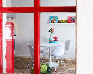 Gezellige eetruimte door raam gezien in Casa Juan Carlos vakantiehuis in Hoorn, Terschelling.