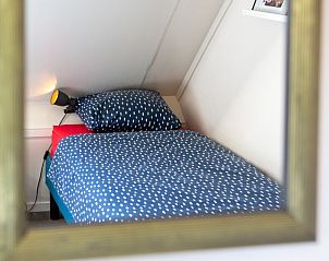 Knusse slaapkamer weerspiegeld in spiegel van Casa Juan Carlos vakantiehuis in Hoorn, Terschelling.