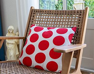 Stijlvolle stoel bij raam in Casa Juan Carlos vakantiehuis op Terschelling voor ontspanning.