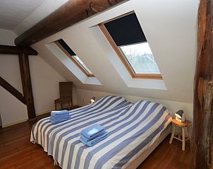 Sfeervolle slaapkamer met dakramen in Zeeduin vakantiehuis, Terschelling.