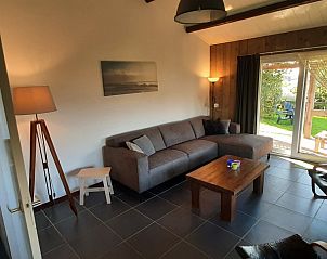 Lichte woonkamer met uitzicht op tuin in Bungalow de Hek, Hoorn, Terschelling. Vakantiehuis op de Waddeneilanden.