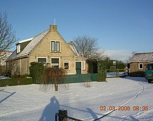 Winterse sfeer bij de Dwarskamp fam. Smit, een gezellige vakantiewoning in Landerum, Terschelling, met sneeuw bedekte tuin en serene omgeving.