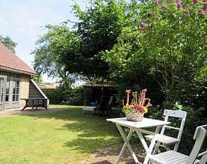 Rustige tuin bij Hannemart vakantiehuis in Lies, Terschelling met zitjes en groen.