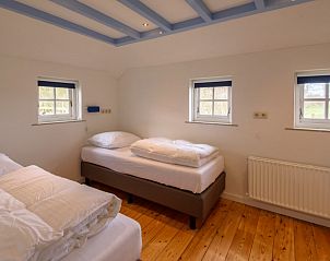 Slaapkamer in Het Goeie op Terschelling, Lies, met twee eenpersoonsbedden en uitzicht op de natuur van Terschelling.