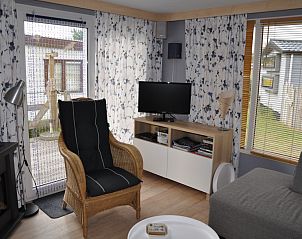 Zithoek in Chalet James, West, Terschelling, met rieten stoel en televisie.