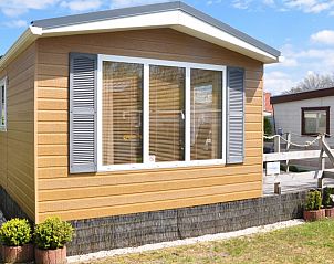 Voorzijde van Chalet James, West, Terschelling, met grote ramen en groene omgeving.