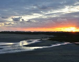 Adembenemende zonsondergang bij West, Terschelling, dichtbij Chalet James, met reflecties op het water.