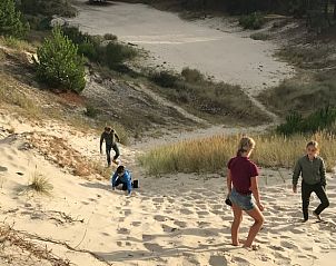 Kinderen spelen in de duinen nabij Vakantiehuisje in West Terschelling, genieten van de natuur op de Waddeneilanden.