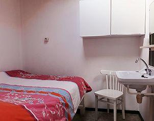 Slaapkamer in appartement West, Terschelling, Waddeneilanden met eenpersoonsbed en wastafel.