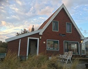 Buitenaanzicht van BosenDuin vakantiehuis in West aan Zee, Terschelling met terrasstoelen.
