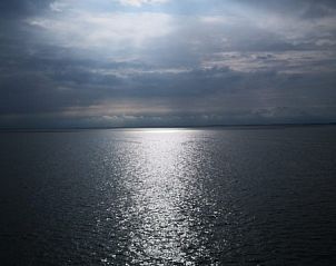 Uitzicht op de zee bij BosenDuin vakantiehuis, West aan Zee, Terschelling tijdens bewolkte dag.