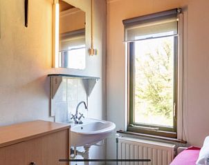 Compacte badkamer in BosenDuin vakantiehuis, West aan Zee, Terschelling met wastafel en spiegel.