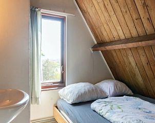 Slaapkamer met houten details in BosenDuin vakantiehuis, West aan Zee, Terschelling.