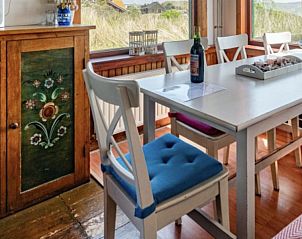 Eetkamer in BosenDuin vakantiehuis, West aan Zee, Terschelling met kleurrijke stoelen.