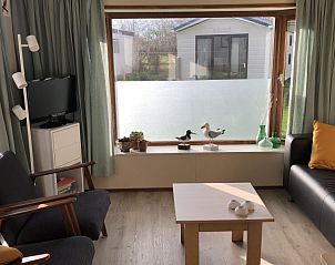 Lichte woonkamer van De Pestvogel chalet in Formerum, Terschelling met uitzicht.