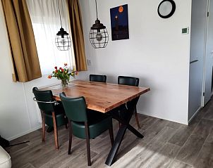 Stijlvolle eetruimte in WadRust chalet op Terschelling met houten tafel en leren stoelen.