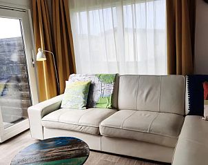 Comfortabele zithoek in WadRust chalet, Midsland Noord, Terschelling met lichtinval.