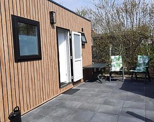 Zonnig terras bij WadRust chalet, Midsland Noord, Terschelling met comfortabele stoelen.