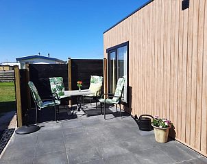 Zonnig terras bij WadRust chalet, Midsland Noord, Terschelling met tuinmeubilair.
