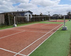 Tennisbaan bij WadRust chalet, Midsland Noord, Terschelling omringd door groen.