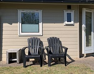 Twee stoelen op het terras van Chalet nr. 12, een vakantiehuis in Midsland Noord, Terschelling, ideaal voor buitenontspanning.