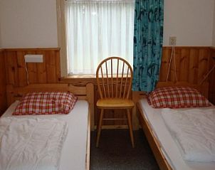 Tweepersoons slaapkamer in vakantiehuis Brunel, Midsland Noord, Terschelling met houten details.