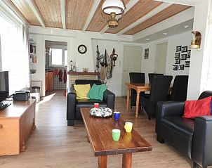 Gezellige woonkamer in Botter vakantiehuis Midsland Noord Terschelling met kleurrijke kussens