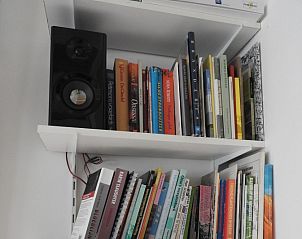 Boekenkast met diverse boeken in Botter vakantieaccommodatie Midsland Noord Terschelling