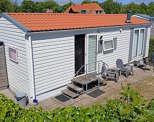 Zijaanzicht van de Utsetter NR 59, Midsland Noord, Terschelling, met groene omgeving en vlag.