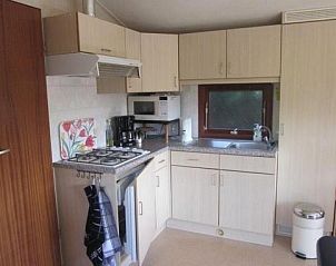 Functionele keuken van Koekoeksdne chalet, Midsland Noord, Terschelling, met moderne apparatuur en raam met uitzicht.