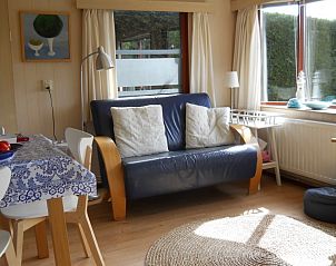 Zonnige woonkamer in Koekoeksdne chalet, Midsland Noord, Terschelling, met comfortabele bank en decoratieve accenten.