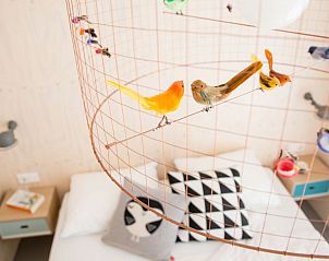 Sfeervolle slaapkamer in Florizand, Midsland Noord, Terschelling, met creatieve decoraties.