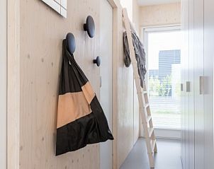 Entreehal in Florizand, Midsland Noord, Terschelling, met praktische opbergruimte en ladder.