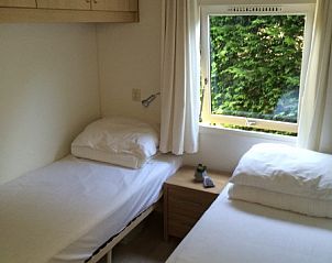Slaapkamer met twee bedden in Chalet DOMETO, Midsland Noord, ideaal voor een ontspannen verblijf.