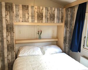 Knusse tweepersoonsslaapkamer in Chalet DOMETO, Midsland Noord, met houten accenten.