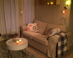 Sfeervolle woonkamer in Chalet DOMETO, Midsland Noord, met zachte verlichting en comfortabele bank.