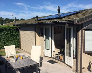 Chalet DOMETO in Midsland Noord, Terschelling met een uitnodigend terras voor buitenmaaltijden.
